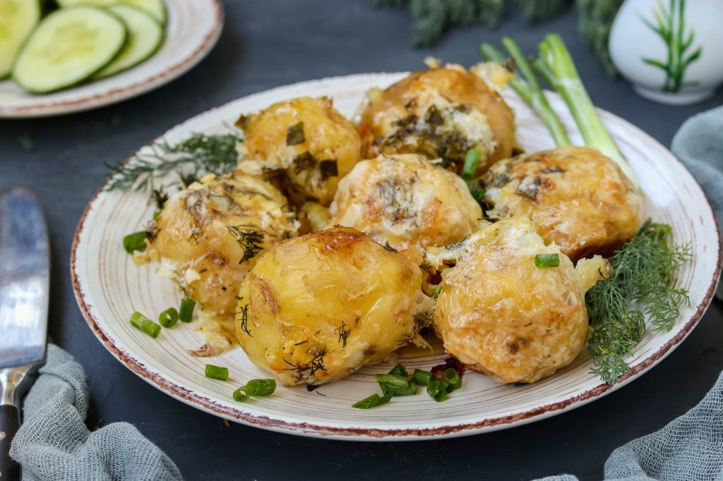 Mit Käse überbackene Kartoffeln und Frühlingszwiebeln: leckere Beilage