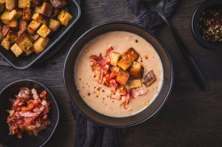 Schale mit Maronencremesuppe mit knusprigem Speck und Croûtons.