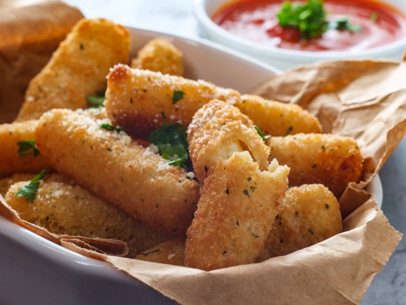 Mozzarella-Sticks aus der HeiÃŸluftfritteuse in einer Schale. Daneben ein SchÃ¤lchen mit Ketchup.