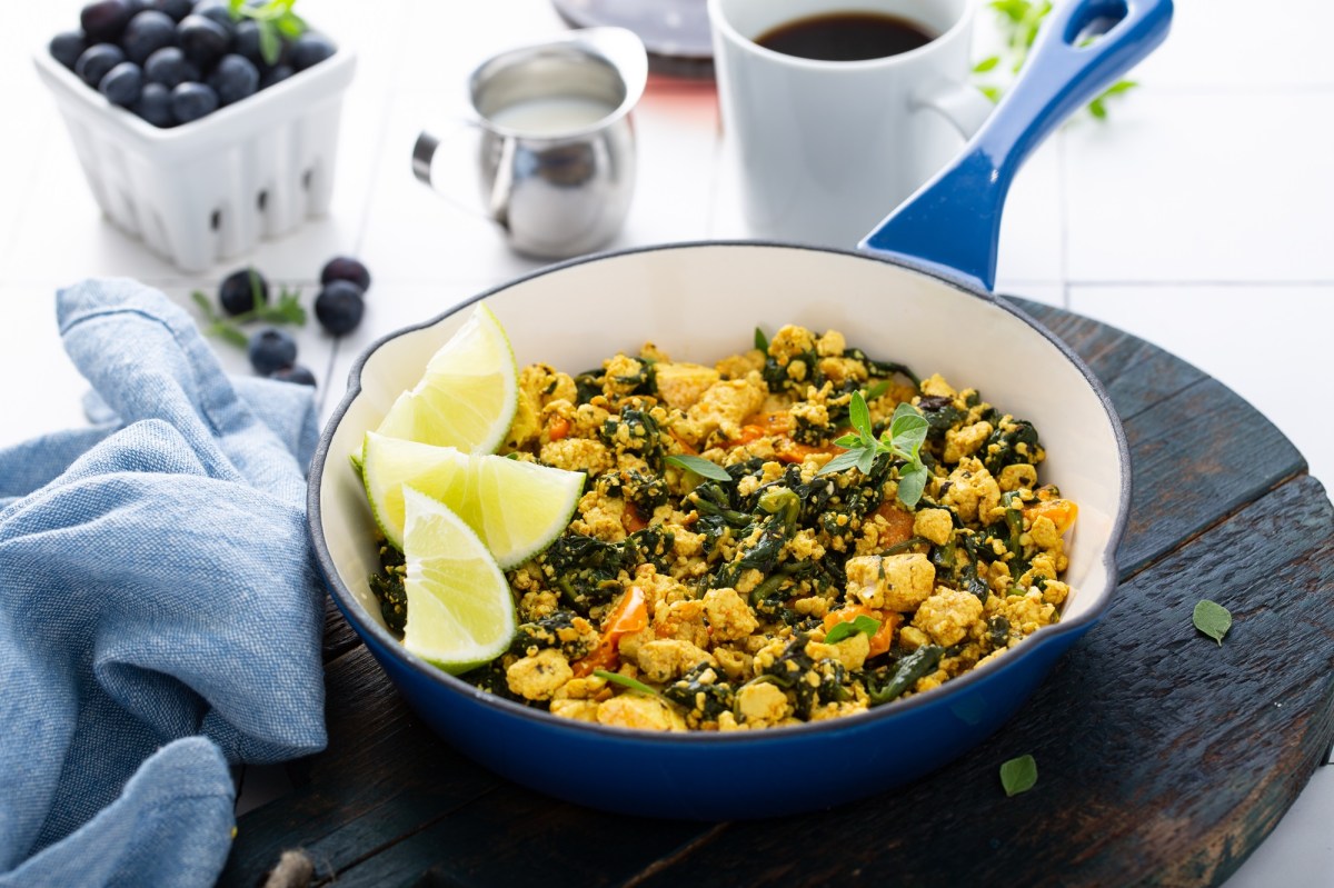 RÃ¼hrtofu in einer blauen Pfanne, garniert mit Zitrone.