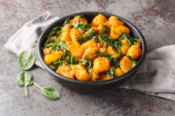 Aloo Palak: Kartoffel-Spinat-Curry in einer schwarzen Schale.