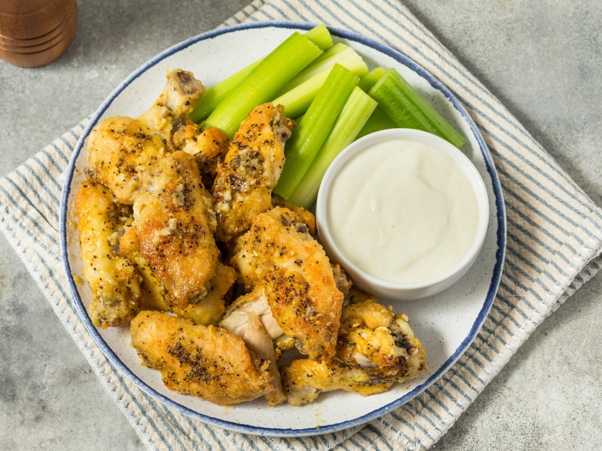 Lemon Pepper Wings mit Selleriestangen und Dip.