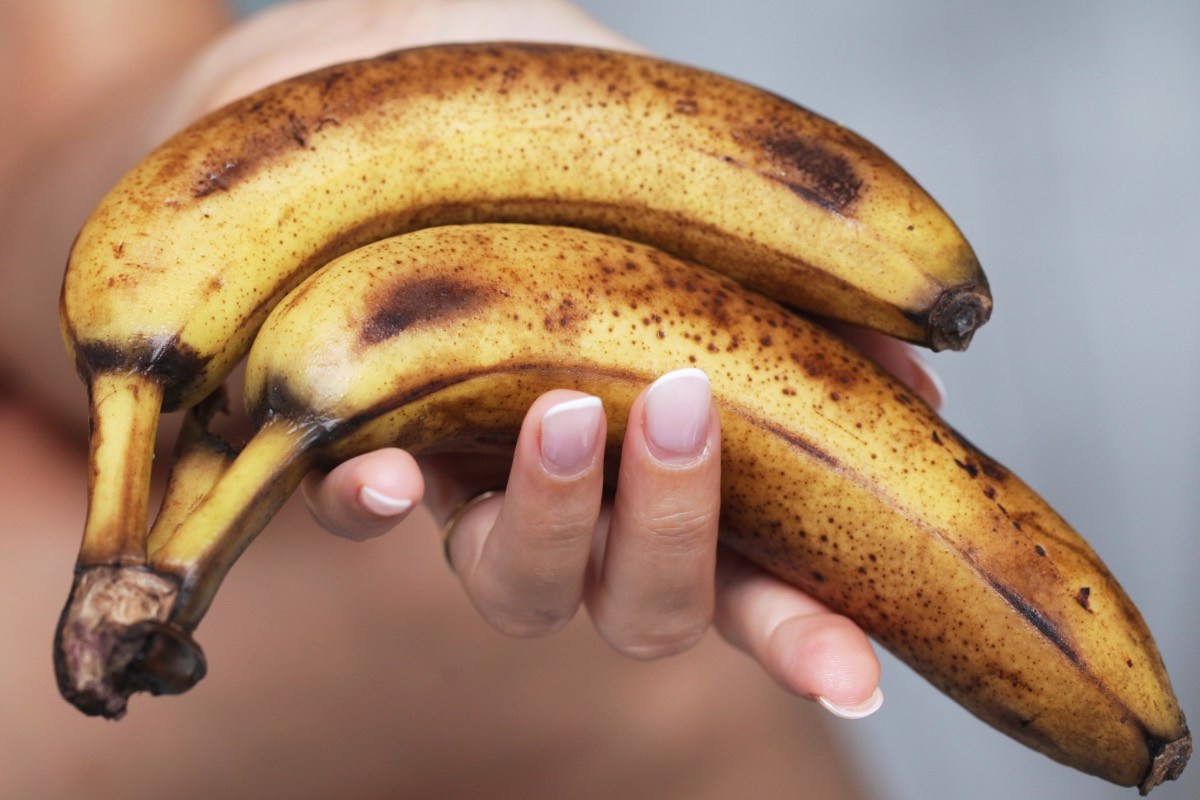 Reife Bananen verwerten: Frauenhand hält reife Bananen.