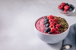 Eine Açai-Bowl, getoppt mit frischen Früchten, Kernen und Nüssen.