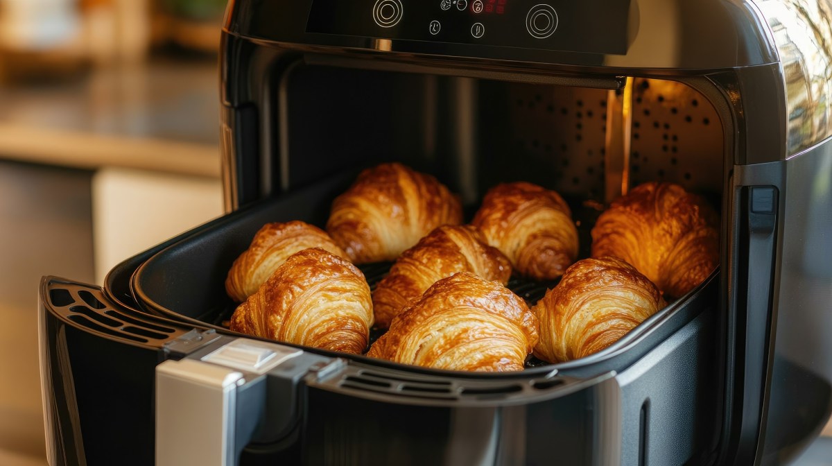 Airfryer-Frühstück: mehrere kleine Croissants im Korb einer Heißluftfritteuse.