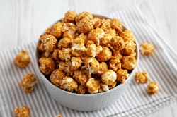 Schale mit Karamell-Popcorn auf gestreiftem Tischtuch