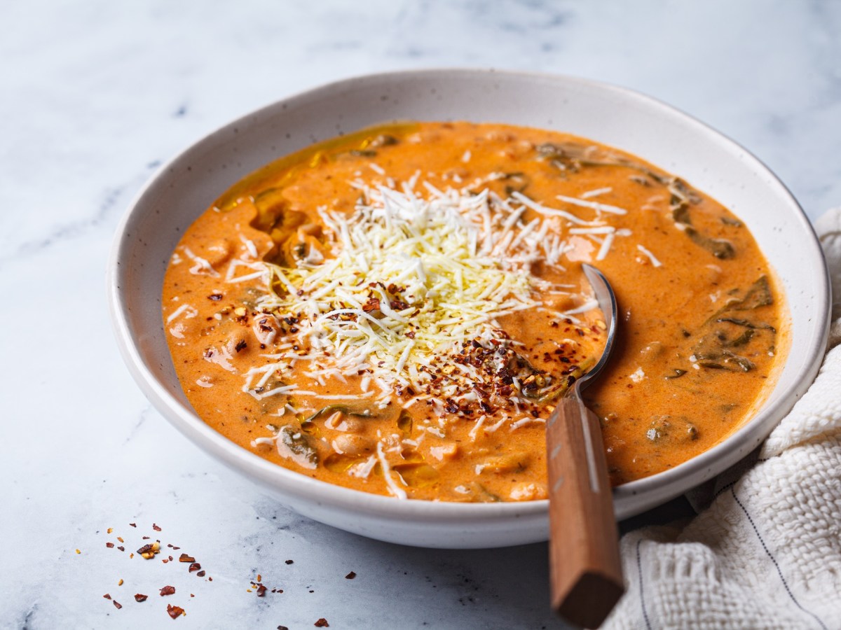 Eine Schüssel mit Tomaten-Bohnen-Suppe, bestreut mit Parmesan.